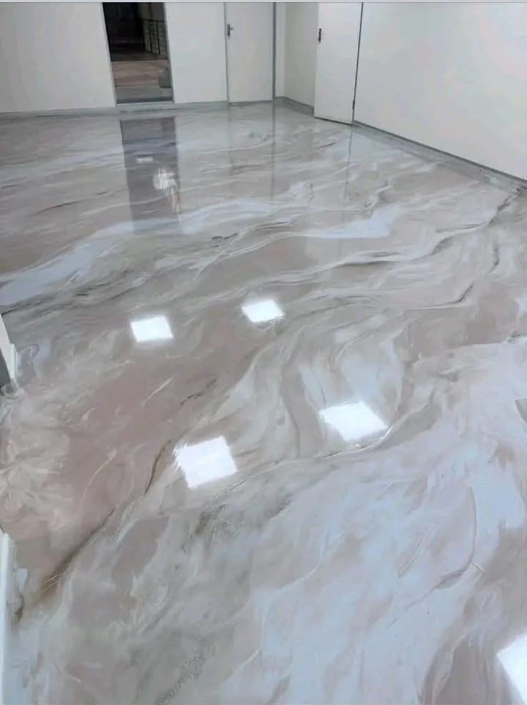 Large bright room completed with a grey and white marble-effect epoxy floor