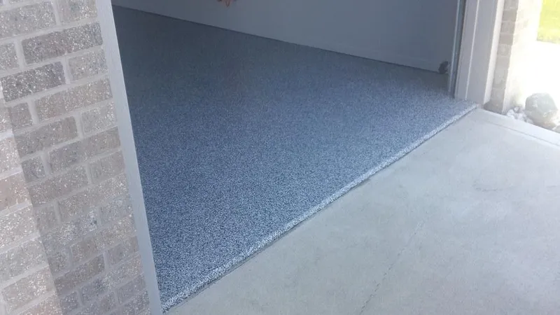 Blue-gray flake garage floor meeting the driveway